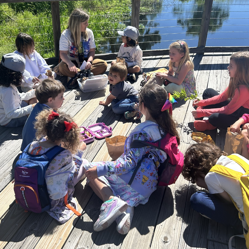 A group of students, with a teacher, learning on a pier in Bluffton, SC